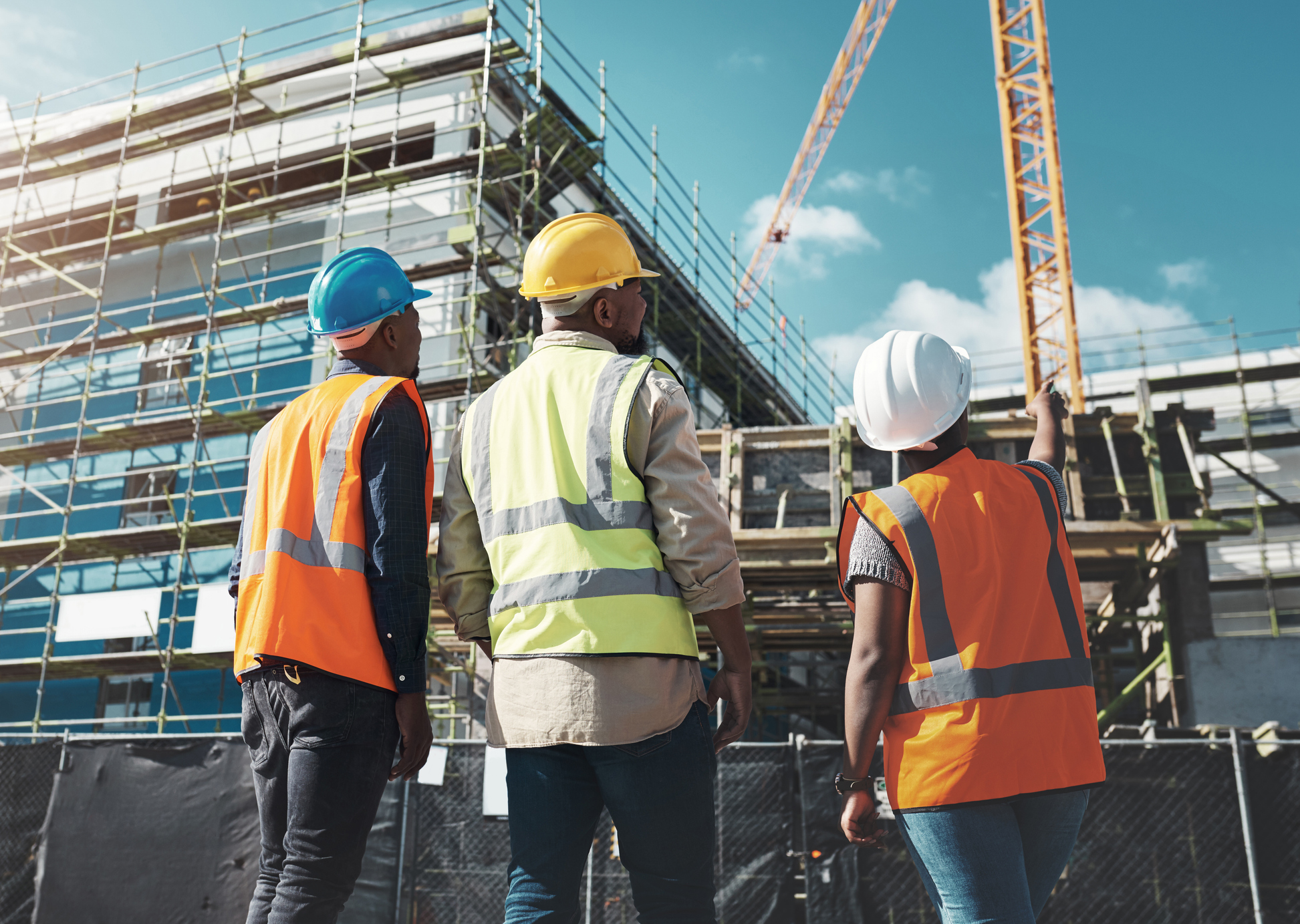 Construction workers observing building progress site.