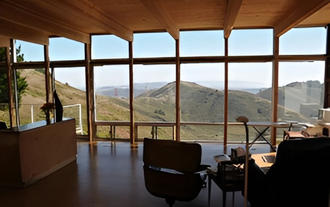 Modern room with mountain view through windows.