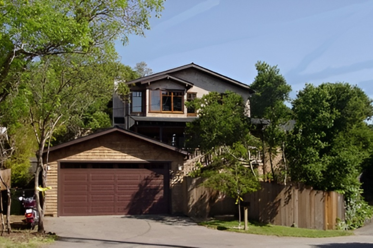 Two-story house surrounded by trees.