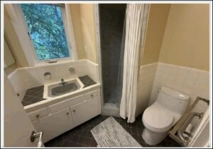 Small beige bathroom with shower, sink, toilet