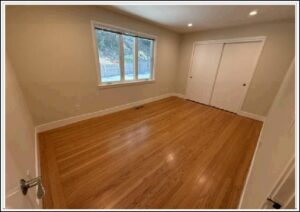 Empty bedroom with hardwood floors and closet