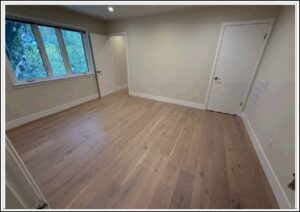 Empty room with light hardwood flooring and window