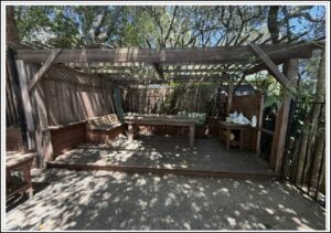 Outdoor shaded pergola with benches and table