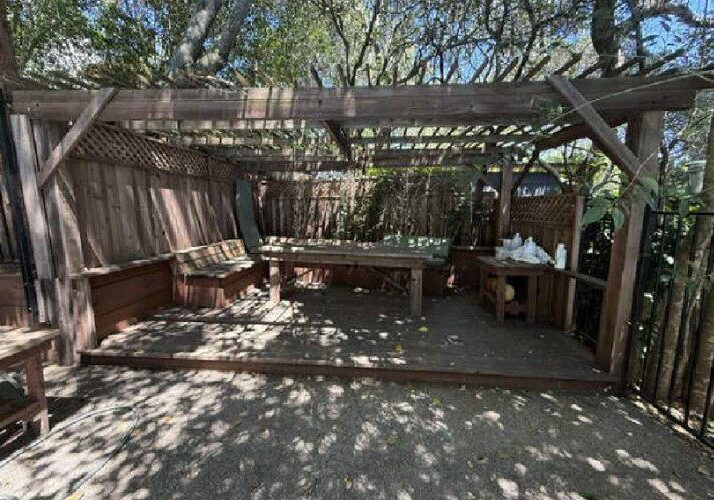 Outdoor shaded pergola with benches and table