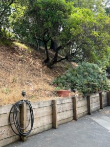 Driveway with wooden retaining wall and hose