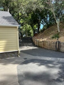 Driveway curving uphill beside yellow house