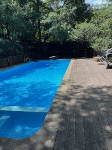Backyard swimming pool with wooden deck
