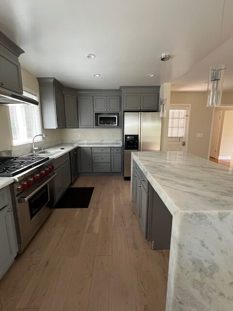 Gray kitchen with marble island and stainless appliances