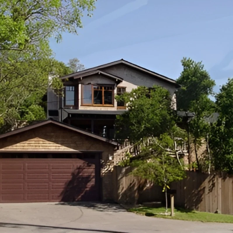 Two-story house surrounded by trees.